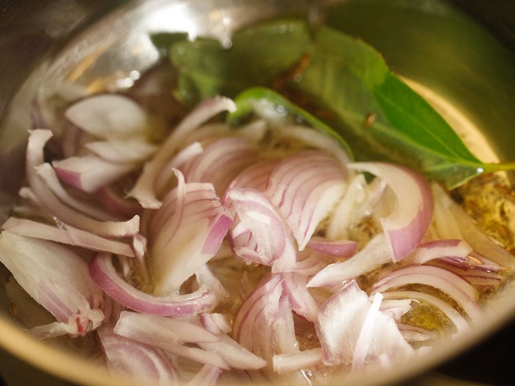 adding sliced onions in the pan.