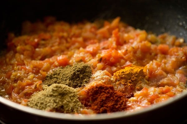 spiced powders added to tomato onion masala