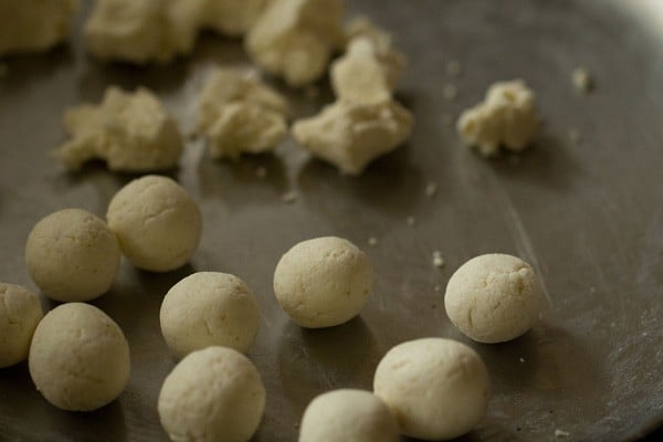 making rasgulla - half of the plate has been rolled into balls, while half of the plate is still in small rough pieces