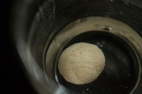 checking rasgulla for doneness in water - it sank to the bottom, so it is cooked