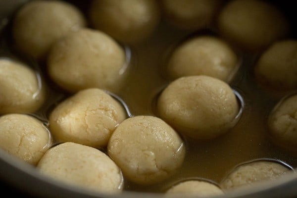 rasgulla in a serving bowl with syrup