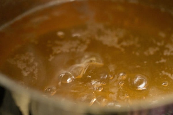 sugar syrup in a pan that is boiling for rasgulla recipe