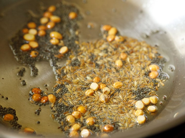 cumin seeds added to pan for making suji ki idli. 
