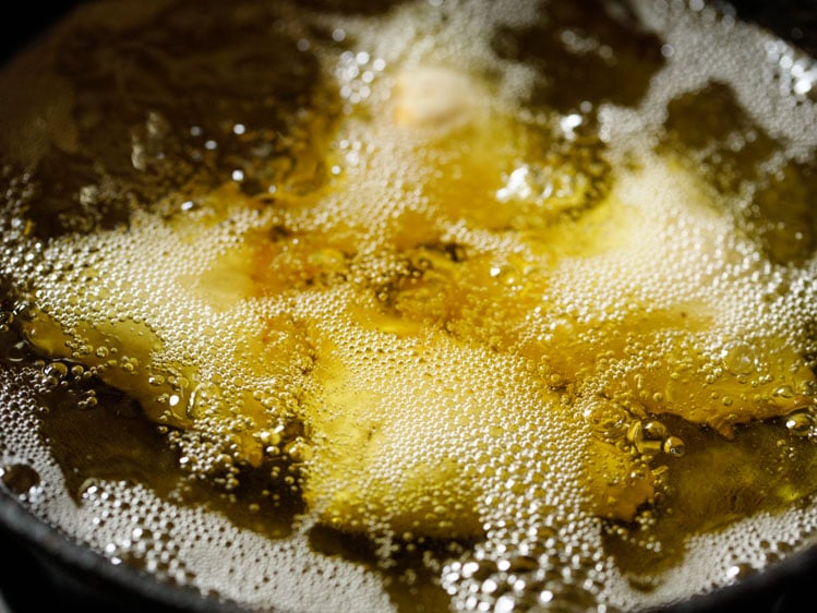 samosa being fried in hot oil