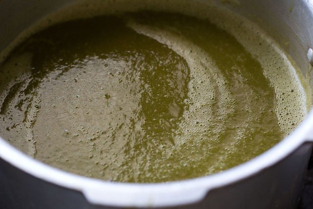 adding greens puree in a pan to simmer more.