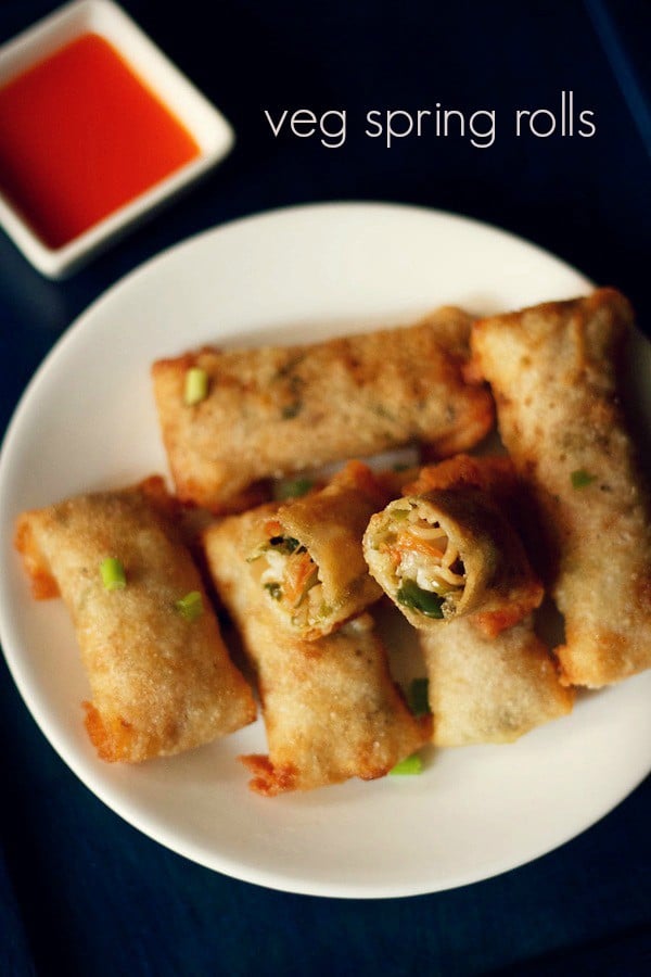 spring rolls on a white plate with halved roll showing the vegetable filling inside