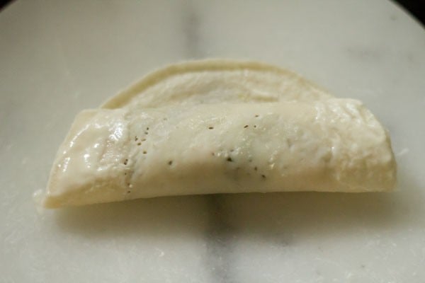 spring roll rolled up halfway with filling then coated with paste to seal