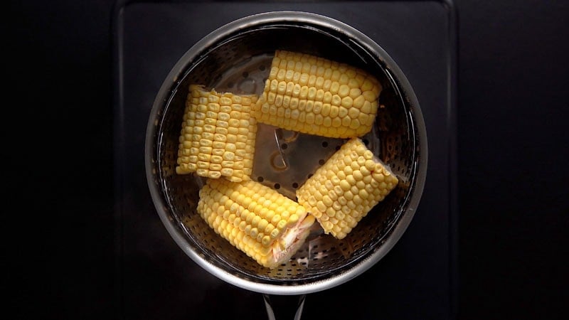 quartered corn cobs on the steamer pan