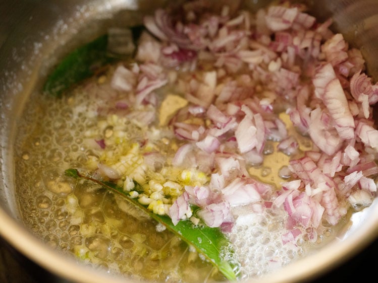 chopped garlic, onion, bay leaves and butter in steel pan