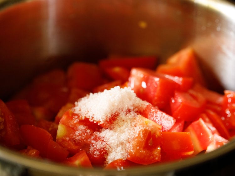 chopped tomatoes with salt on top added in steel pan