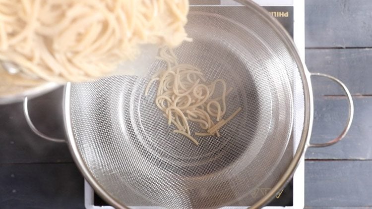 straining noodles in a colander