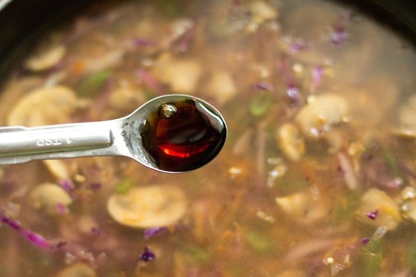 adding soy sauce to the soup